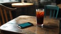 Cold brew coffee and smartphone on a wooden table in a cafe Royalty Free Stock Photo