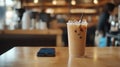 Iced Coffee and Smartphone on Cafe Table with Blurred Barista Background Royalty Free Stock Photo