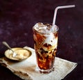 Iced coffee and cream, napkin, brown sugar on a dark background Royalty Free Stock Photo