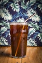 iced espreso coffee drink with tropical green leaf as background