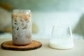 Iced coffee with fresh milk being poured into it showing the refreshing drink