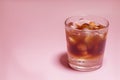 Iced coffee in a glass on pink background. Cold refreshment summer drink