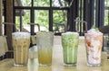 Iced Coffee, Honey Lemon Soda , iced green tea and strawberry smoothie in glass on the wooden table Background glass windows and Royalty Free Stock Photo