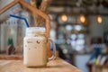 Iced coffee in jug, mug glass cups on the wooden tabletop