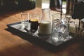 iced coffee latte, ice cubes espresso milk and sweet syrup served in various test tubes on wooden table in morning cafe