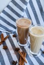 Iced coffee with milk in tall glasses, Cups of tasty frappe coffee, Latte machiato, two cups of cappuccino with cinnamon sticks Royalty Free Stock Photo