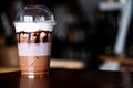 Iced coffee in plastic cup on wooden table at cafe. The best start to any morning Royalty Free Stock Photo