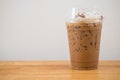 Iced coffee in plastic cup on wooden table at cafe Royalty Free Stock Photo