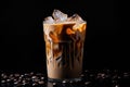 Iced coffee with swirling milk in a glass, coffee beans scattered