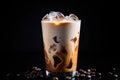 Iced coffee with swirling milk in a glass, coffee beans scattered