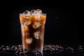 Iced coffee with swirling milk in a glass, coffee beans scattered