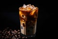 Iced coffee with swirling milk in a glass, coffee beans scattered