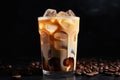 Iced coffee with swirling milk in a glass, coffee beans scattered