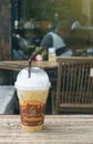 Iced coffee in takeaway cup on wood table with blurred coffee cafe background, light effect added ,selective focus Royalty Free Stock Photo