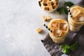 Iced coffee in tall glasses with cream and pieces of sugar, mint Royalty Free Stock Photo