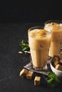 Iced coffee in tall glasses with cream and pieces of sugar, mint Royalty Free Stock Photo