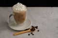 Iced coffee with whipping cream and bean in the insulated glass mug