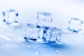 Iced cubes melting on a blue table with reflection. Water. Melting of ice. Royalty Free Stock Photo