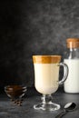 Iced Dalgona coffee in glass mug on dark background. Trendy refreshment creamy whipped coffee. Korean coffee drink.