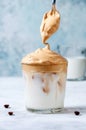 Iced Dalgona Coffee with Spoon on Ligrht Background. Trendy Creamy Whipped Coffee. South Korean Cold Summer Drink