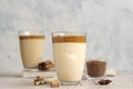 Iced Dalgona coffee in tall glass with spices. A trendy fluffy creamy whipped coffee. Korean coffee drink.