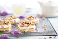 iced donuts with nuts on a cooling rack