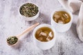 Iced green japanese hojicha tea in cups and leaves in a bowl on the table Royalty Free Stock Photo