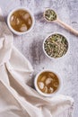 Iced green japanese hojicha tea in cups and leaves in a bowl on the table top and vertical view Royalty Free Stock Photo