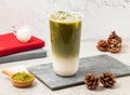 Iced Green tea latte served in disposable glass isolated on board side view of taiwanese iced drink Royalty Free Stock Photo