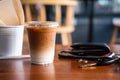 Iced latte coffee in plastic glass and men wallet, phone and key car Royalty Free Stock Photo