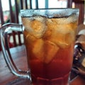 Iced lemon tea with ice cubes in a large glass