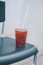 Iced lemon tea in plastic to go cup on chair.Glasses of cold ice tea with lemon, ice, mint on background. Homemade lemonade. Royalty Free Stock Photo