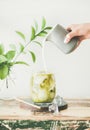 Iced matcha latte with milk pouring fron pitcher in glass Royalty Free Stock Photo