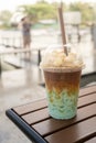 Iced milk green tea mixed milk coffee topping with popcorn, showing separate in a layer the bottom as green tea top by coffee in a