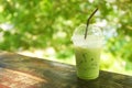 iced milk green tea on wooden table with green bokeh background Royalty Free Stock Photo