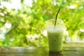 iced milk green tea on wooden table with green nature background Royalty Free Stock Photo