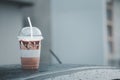 Iced mocha coffee on front roof of car after raining