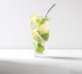 Iced mojito in a tall glass with lime wedges