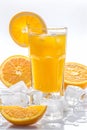 Iced orange juice in a glass with many condensation droplets, surrounded by ice cubes and slices of oranges