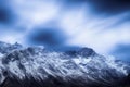 Iced over mountains peaks and cliffs against cold blue sky and feather clouds, created with Generative AI