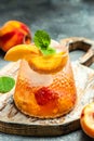 Iced peach cocktail with peach slices, summer Peach cocktail, homemade peach lemonade with ice cubes, and mint in glass Royalty Free Stock Photo