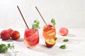 Iced peach tea or cocktail with mint and lobdom,recipe for refreshing summer drink.Two glasses with peach fruit lemonade on light Royalty Free Stock Photo