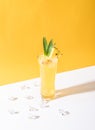 Iced pineapple punch cocktail in glass on yellow background. summer drink Royalty Free Stock Photo