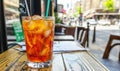 Iced tea on a cafe table on a sunny day with blurred street scene Royalty Free Stock Photo