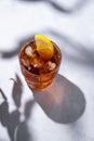 Iced tea, Cuba Libre or Long Island cocktail with cola, lemon and ice in a glass on a blue background with shadow. The concept of Royalty Free Stock Photo