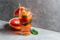 Iced tea with mint and grapefruit on a grey background