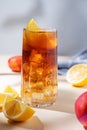 Iced tea with lemon, peach and ice in a tall glass on a yellow background with shadow and fruits. The concept of a refreshing Royalty Free Stock Photo
