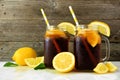 Iced tea in mason jar glasses with lemons, side view against dark wood Royalty Free Stock Photo