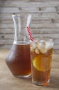 Iced tea with straw, ice cubes and sliced lemon over wooden background Royalty Free Stock Photo