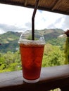 Iced tea on the wooden fence with mountains view